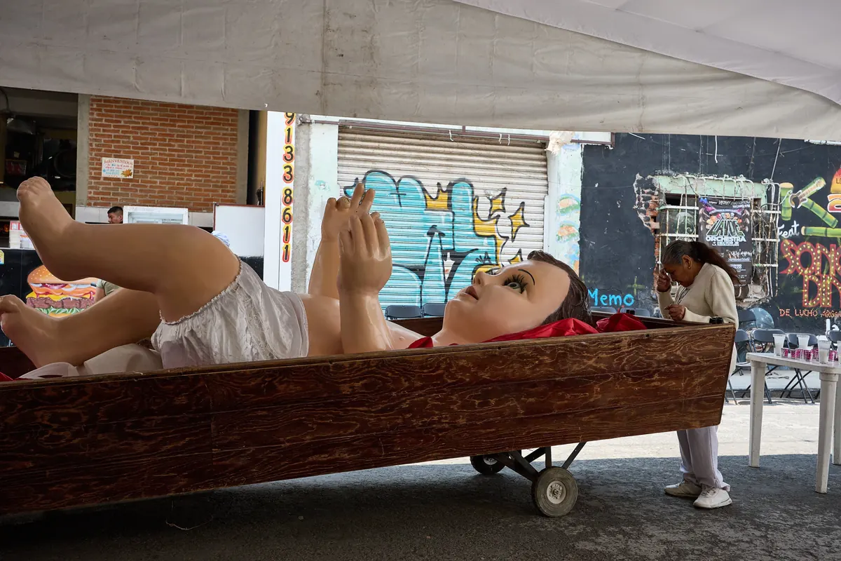 Giant 16-foot Baby Jesus statue surrounded by residents during prayers in Tepito neighborhood, Mexico City.